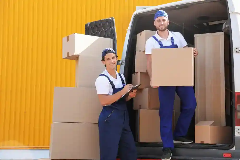 Movers efficiently packing and securing furniture inside a moving truck.